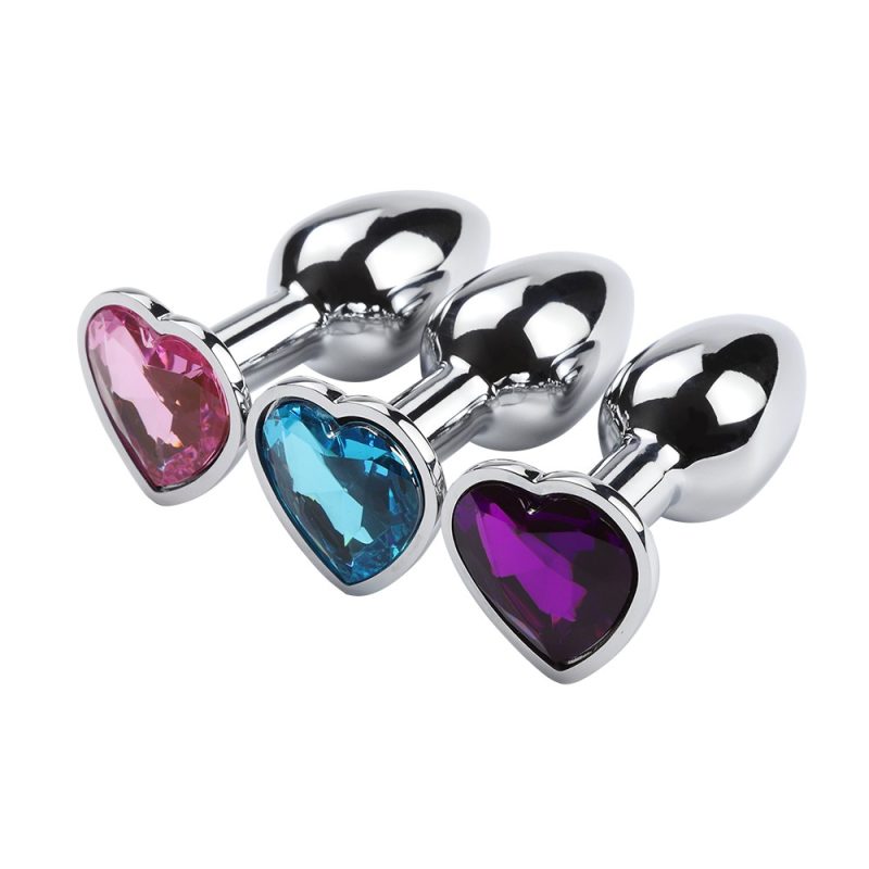 Pink, blue, and purple heart-shaped anal plugs with metallic finish for adult pleasure.