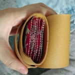 Compact sex toy storage bag with organizer pockets and handle in tan color.